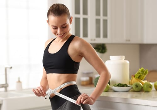 Woman measuring her waist with a tape measure, representing the medically supervised weight loss program at My Doctors Clinic Surfers Paradise