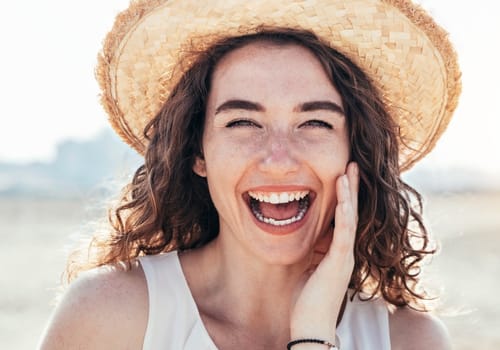 Smiling woman outdoors wearing a straw hat, representing women's health care at My Doctors Clinic in Surfers Paradise